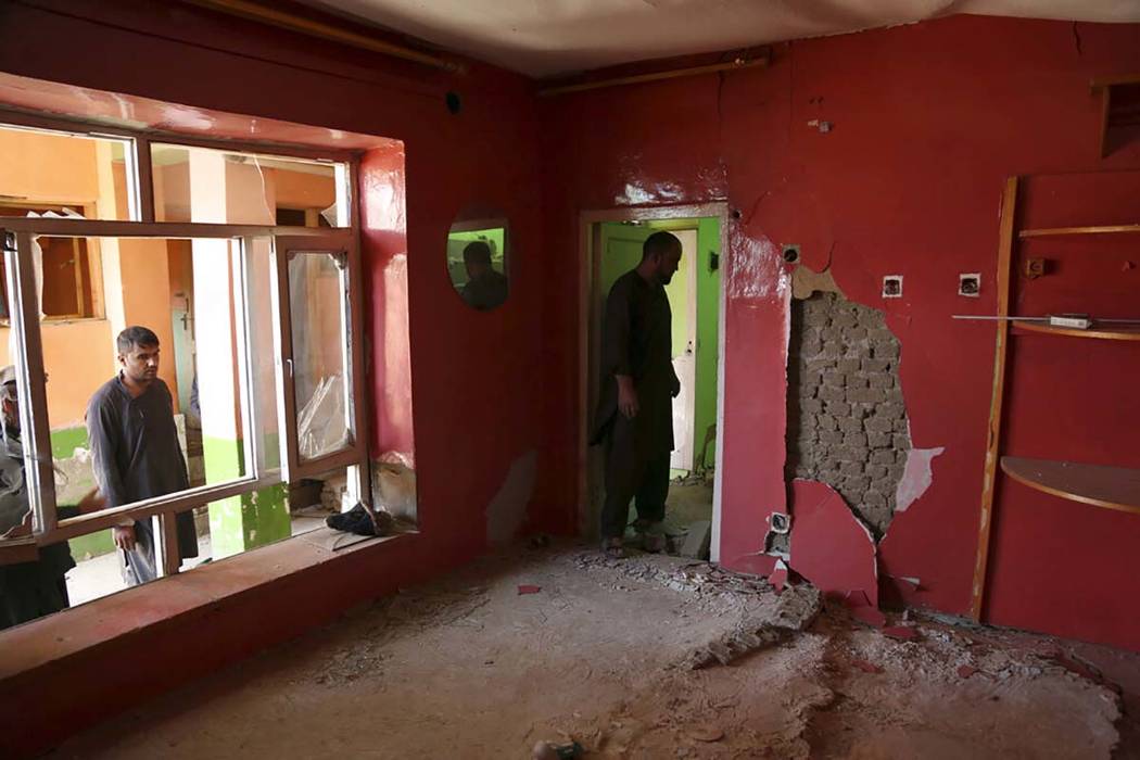 In this Tuesday, Sept. 10, 2019 photo, Afghans inspect their damaged house after a large explos ...
