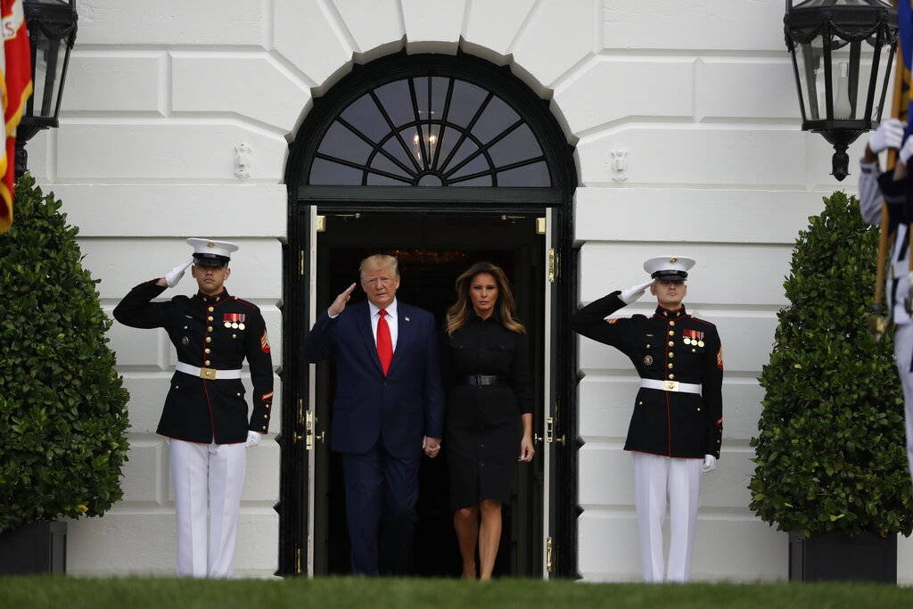 President Donald Trump and first lady Melania Trump walk out to participate in a moment of sile ...