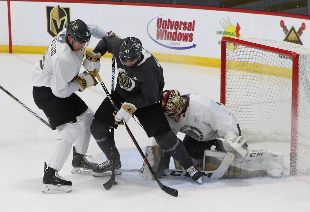 Golden Knights Zach Whitecloud, left, and goalie Maxime Lagace defend Pierre-Edouard Bellemare, ...