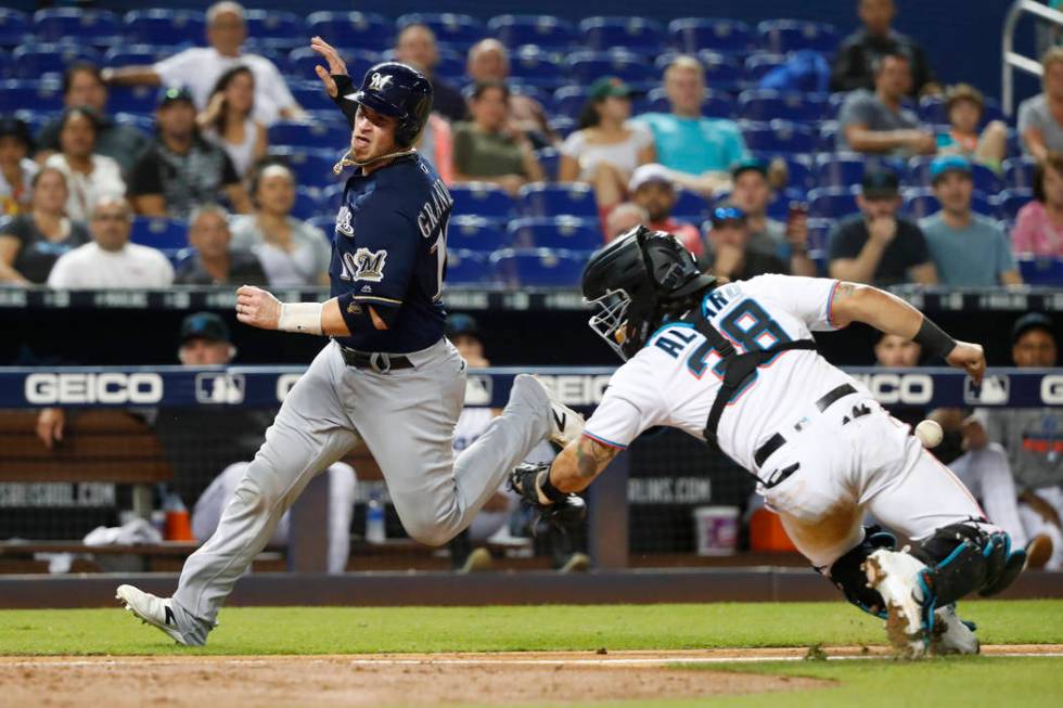 Milwaukee Brewers' Yasmani Grandal (10) heads for home plate to score on a sacrifice fly by Tyl ...