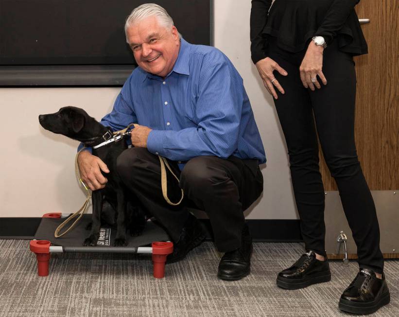 Blaze, a 5-month-old black lab and golden retriever mix, meets with Nevada Gov. Steve Sisolak a ...