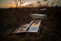 A shattered and water-filled coffin lays exposed to the elements in the aftermath of Hurricane ...