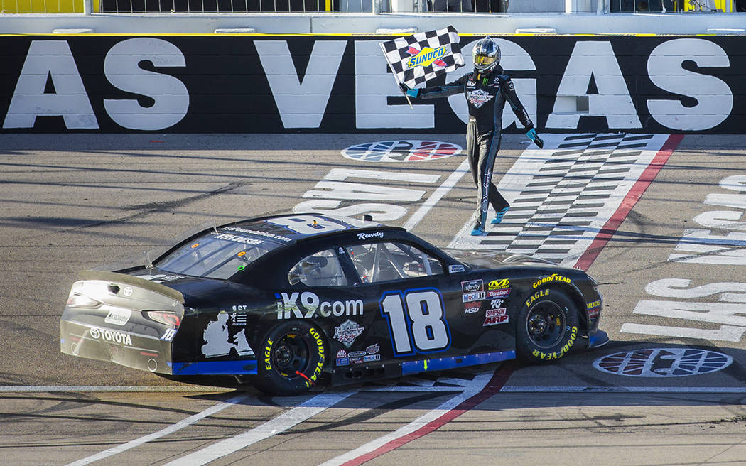 Kyle Busch (18) carries the checkered flag after winning the NASCAR Xfinity Series Boyd Gaming ...