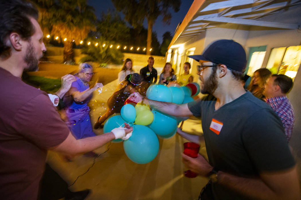 Guests pop balloons for a baby sex reveal during the secretive Oakey Family Supper Club event o ...