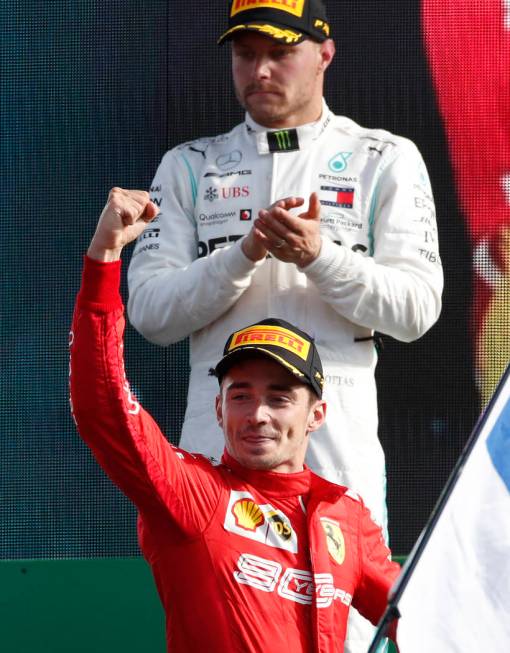 Ferrari driver Charles Leclerc of Monaco, bottom, celebrates with second placed Mercedes driver ...