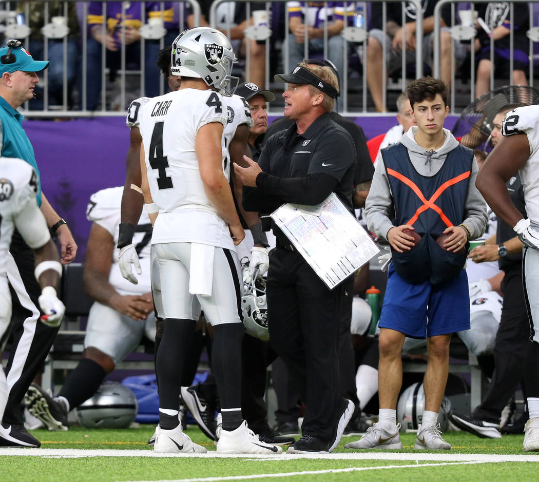 Oakland Raiders head coach Jon Gruden, right, has a conversation with quarterback Derek Carr (4 ...