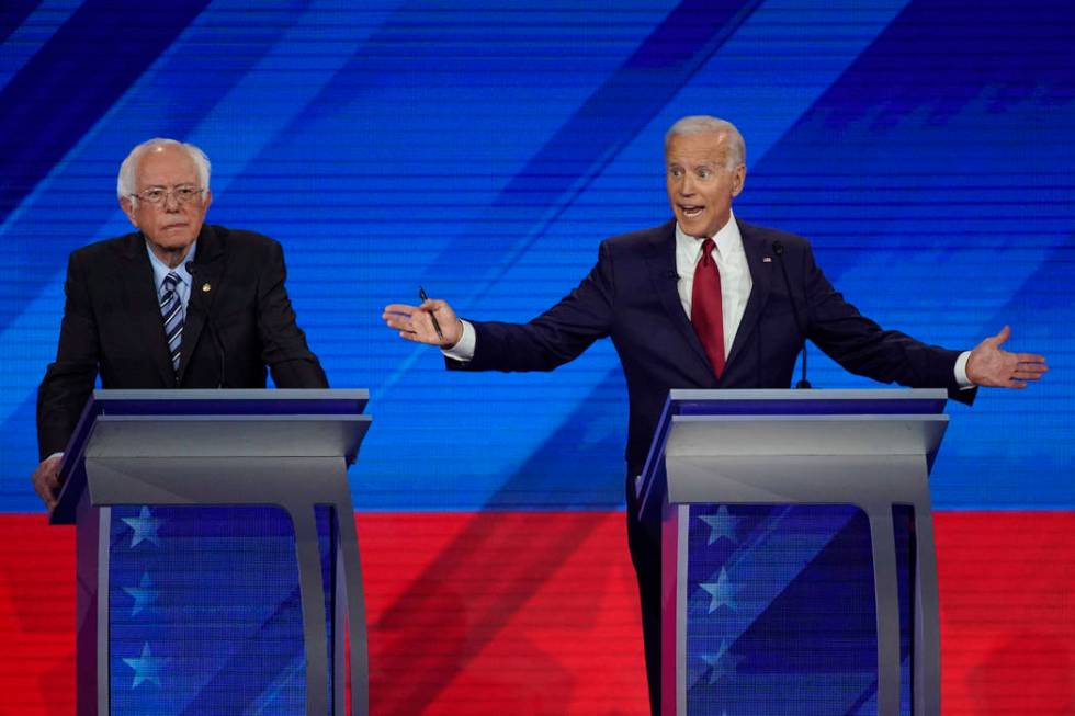 Sen. Bernie Sanders, I-Vt., left, listens as former Vice President Joe Biden, right, responds t ...