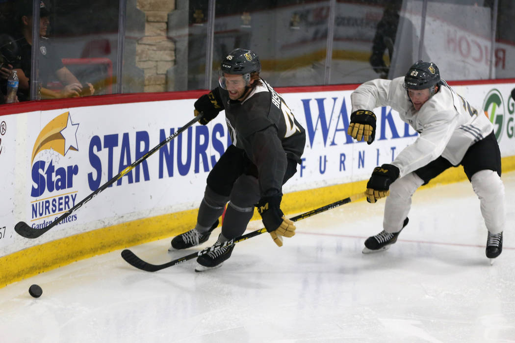 Vegas Golden Knights defenseman Jake Bischoff (45) and center Patrick Brown (23) go for the puc ...