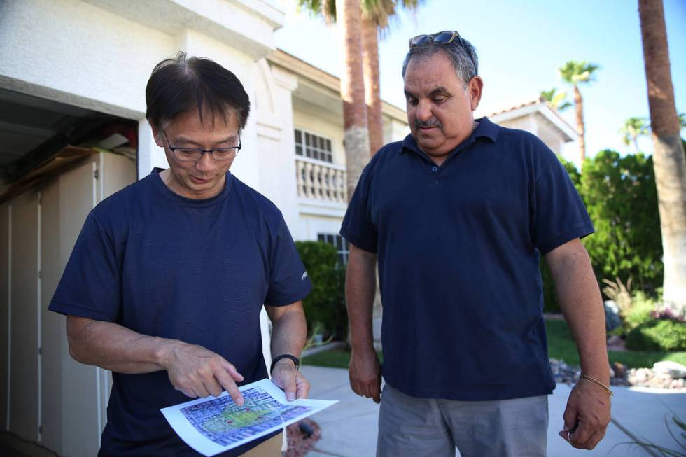 Wayne Niimi, left, in front of the home of his neighbor Victor Padron, shows on a map the three ...