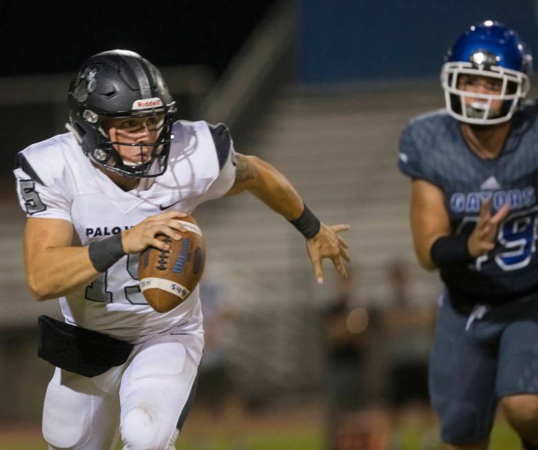 Palo Verde senior quarterback Paul Myro (15) scrambles past Green Valley senior defensive end Z ...