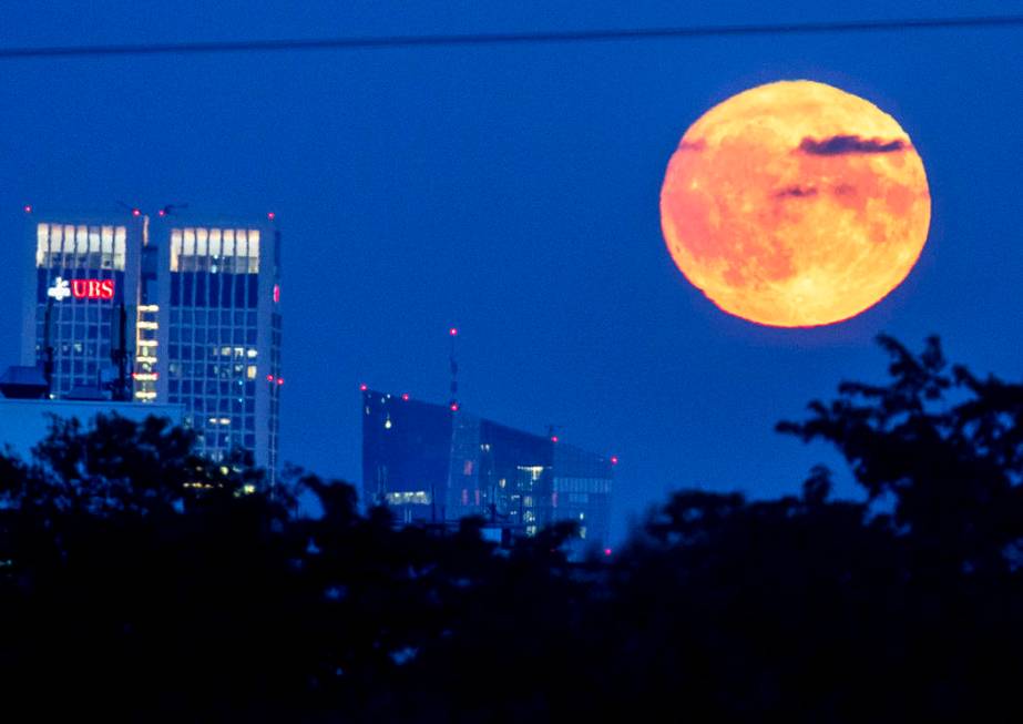 The full moon rises over the European Central Bank, center, in Frankfurt, Germany, Friday, Sept ...