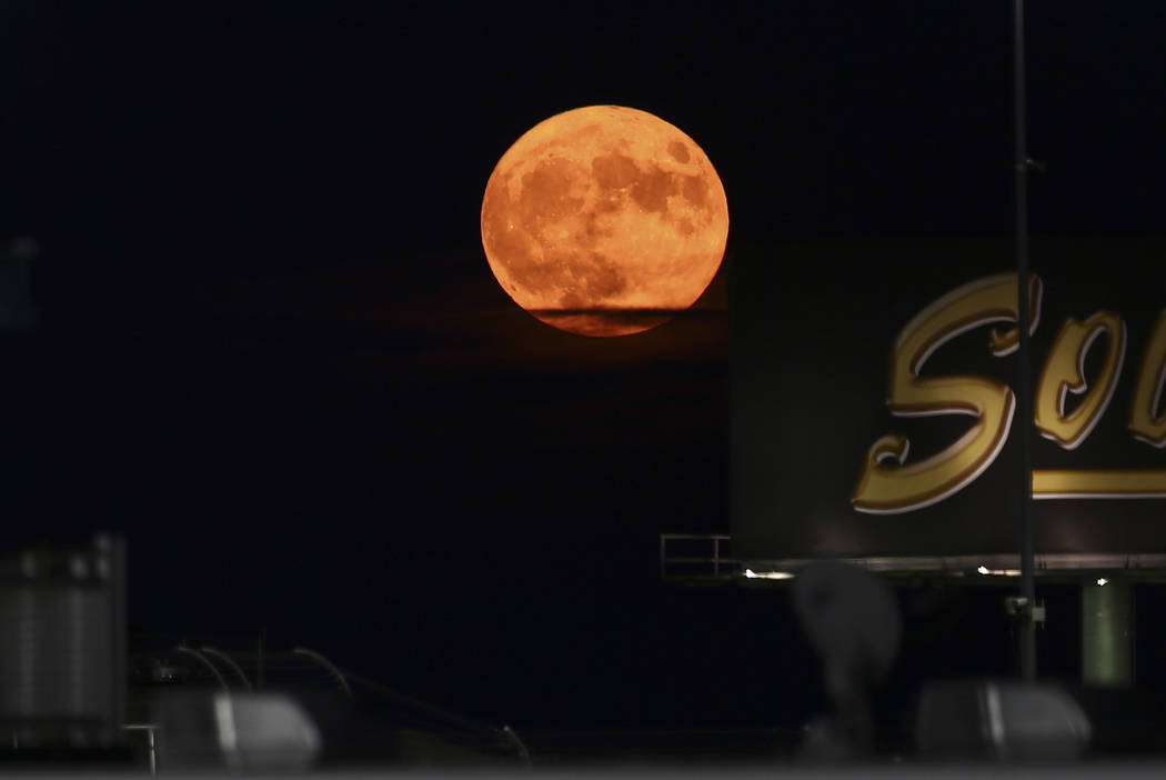 A harvest moon rises as drivers compete in the NASCAR World of Westgate 200 Truck Series auto r ...