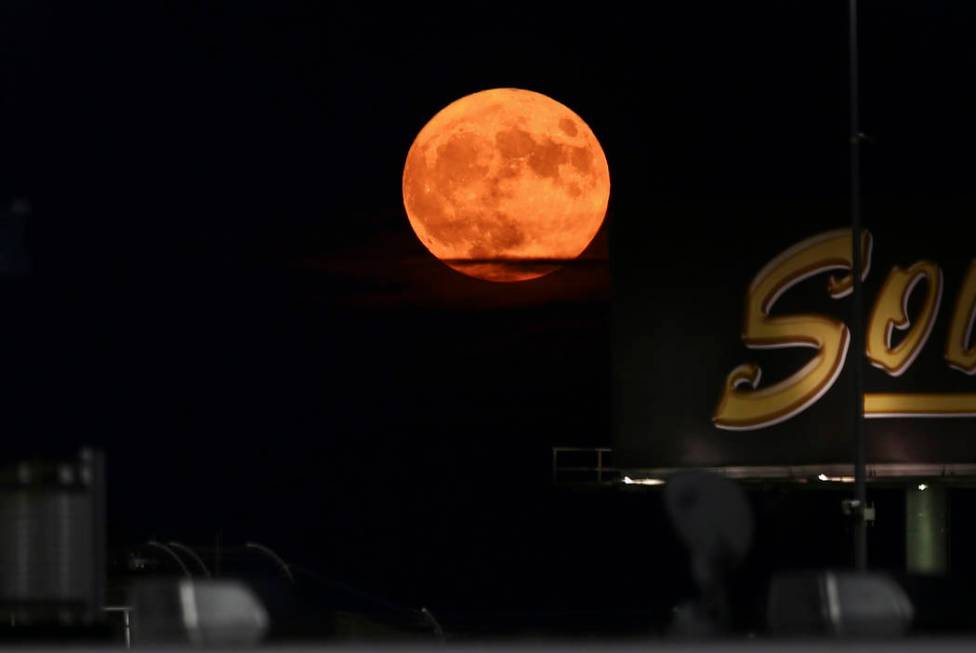 A harvest moon rises as drivers compete in the NASCAR World of Westgate 200 Truck Series auto r ...