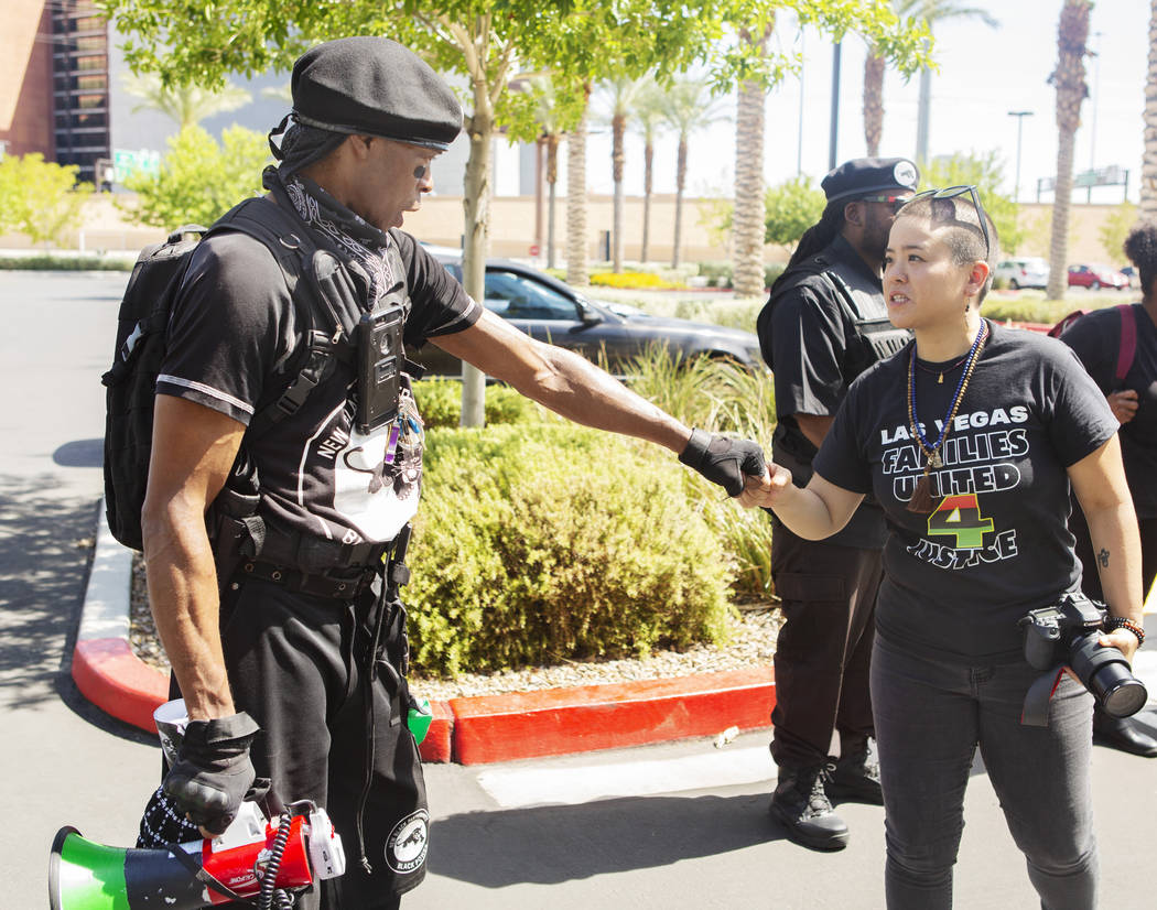 Jay Jackson, local chairman of the New Black Panther Party, left, fist bumps to Nissa Tzun, rig ...