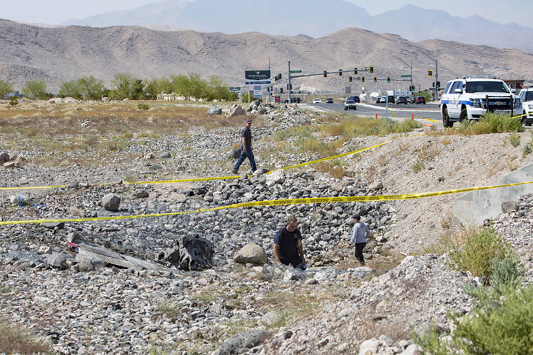 Federal Aviation Administration employees investigate the scene of a fatal airplane crash from ...