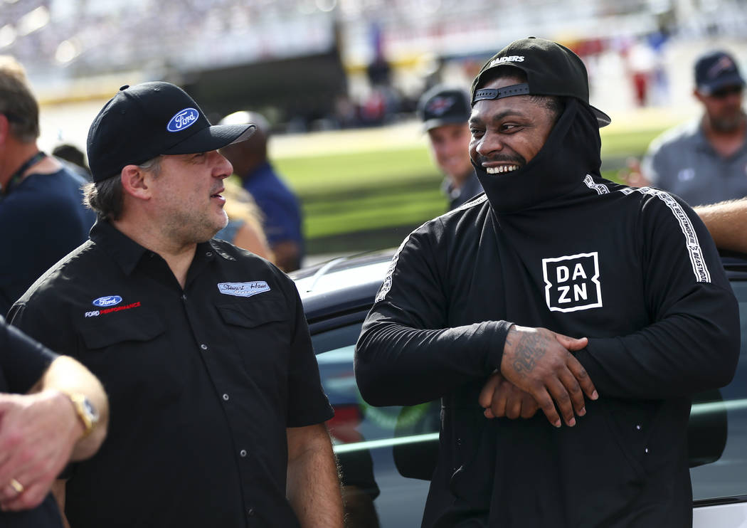 Team owner Tony Stewart, left, talks with former NFL football player Marshawn Lynch before a NA ...