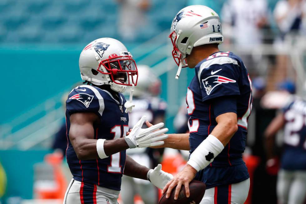 New England Patriots quarterback Tom Brady (12) greets wide receiver Antonio Brown (17) before ...