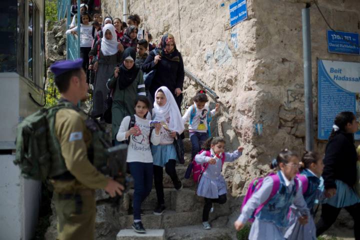 FILE - In this March 21, 2019 file photo, an Israeli solider stands guard as Palestinian school ...
