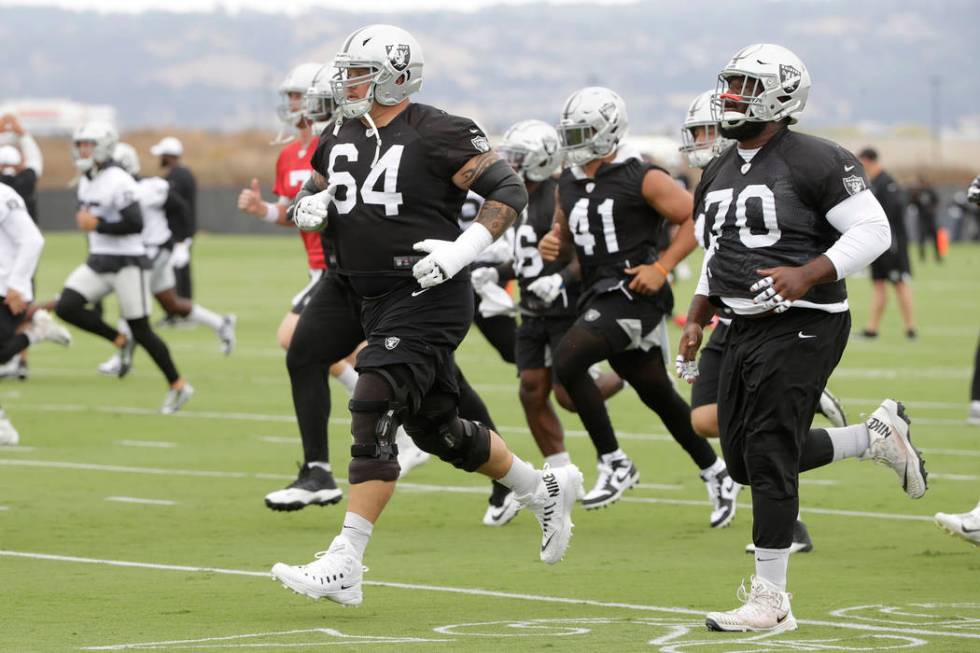 Oakland Raiders' Richie Incognito (64) jogs next to Jonathan Cooper (70) during NFL football pr ...