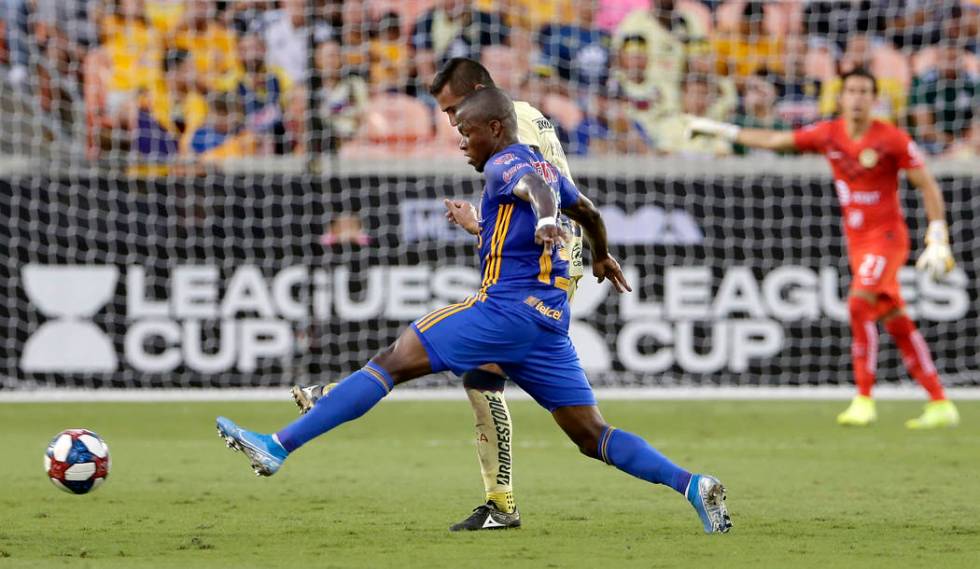 Tigres' Enner Valencia, front, moves the ball past Club America's Paul Aguilar, back, during th ...