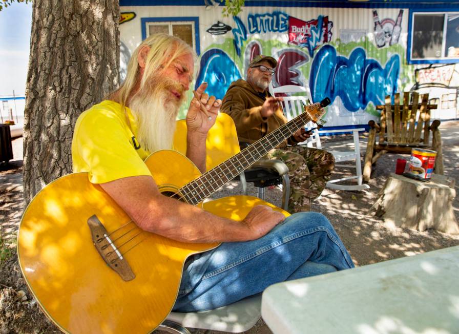 Longtime neighbor and musician Bill Schneider relaxes with his guitar outside the Little A'Le'I ...