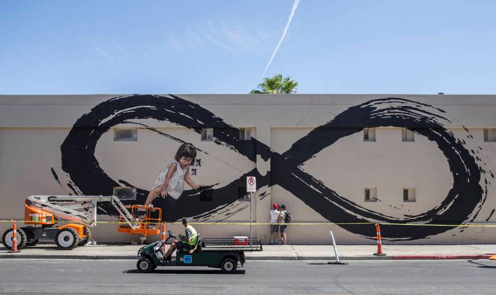 Lithuania artist Ernest Zacharevic, center, and Nicky Holiday discuss Zacharevic's mural in pre ...