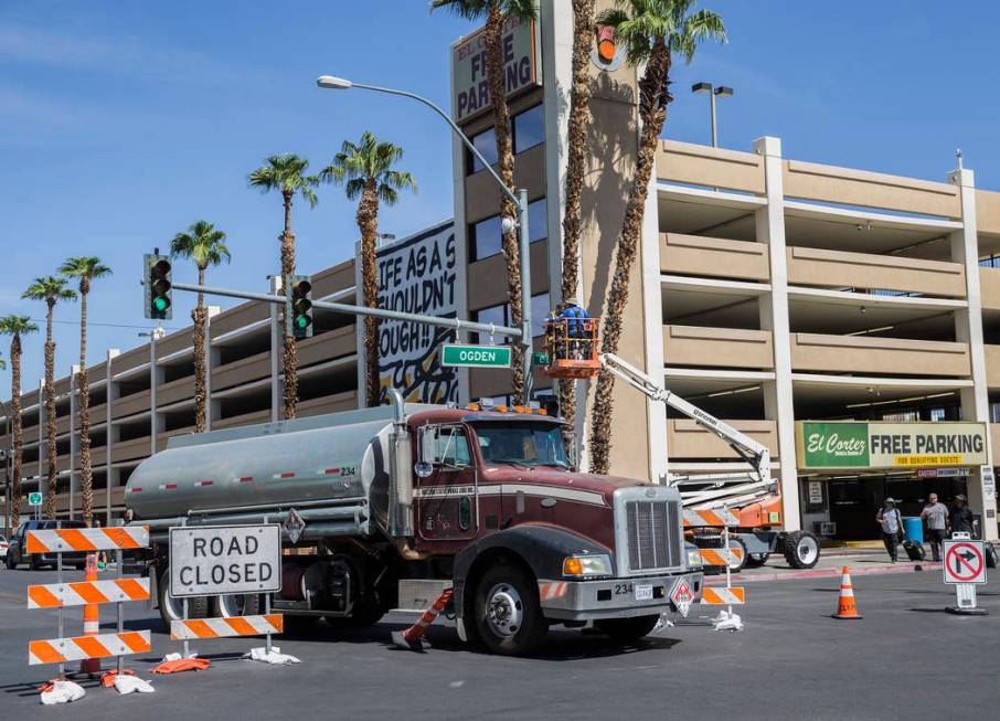 Workers at the intersection of North 7th Street and East Ogden Avenue prepare the area for Life ...