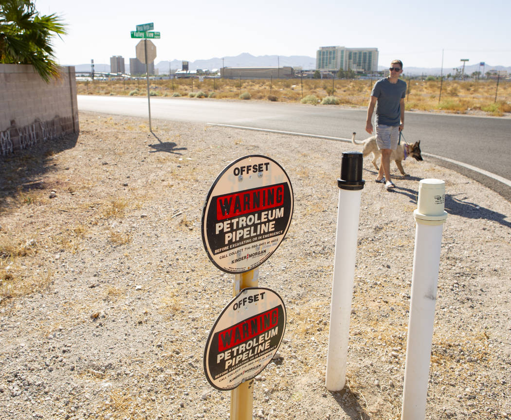 Trevor Schneider walks his dog near a Petroleum Pipeline sign at South Valley View Boulevard an ...