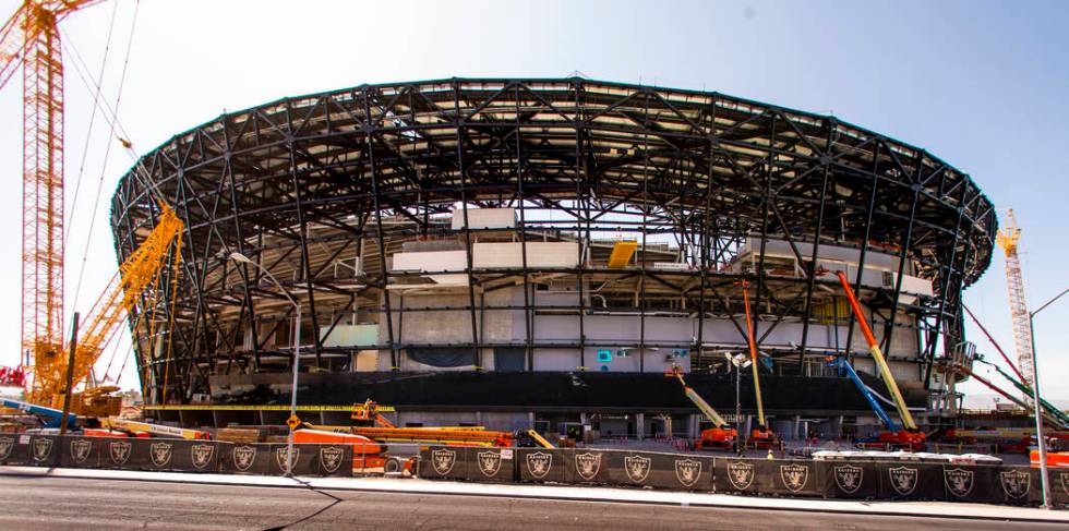 Crews work to install glass panes along the lower lever of Allegiant Stadium on Tuesday, Sept. ...