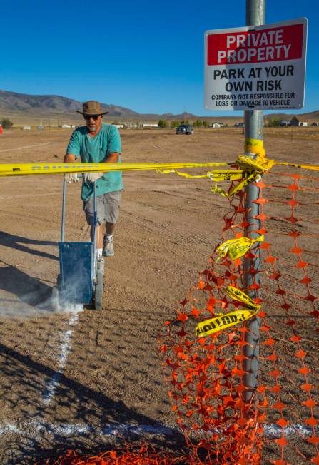 Douglas Benedetti chalks out parking lines across from the Little A'Le'Inn which is the site of ...