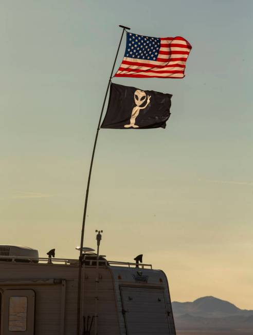 Two flags fly above and RV which is camped out in the desert as the Alienstock and Area 51 Base ...