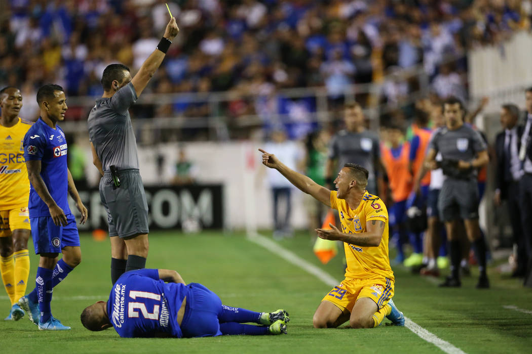 Tigres' Jesus Duenas (29), right, receives a yellow card for a foul against Cruz Azul's Jonatha ...