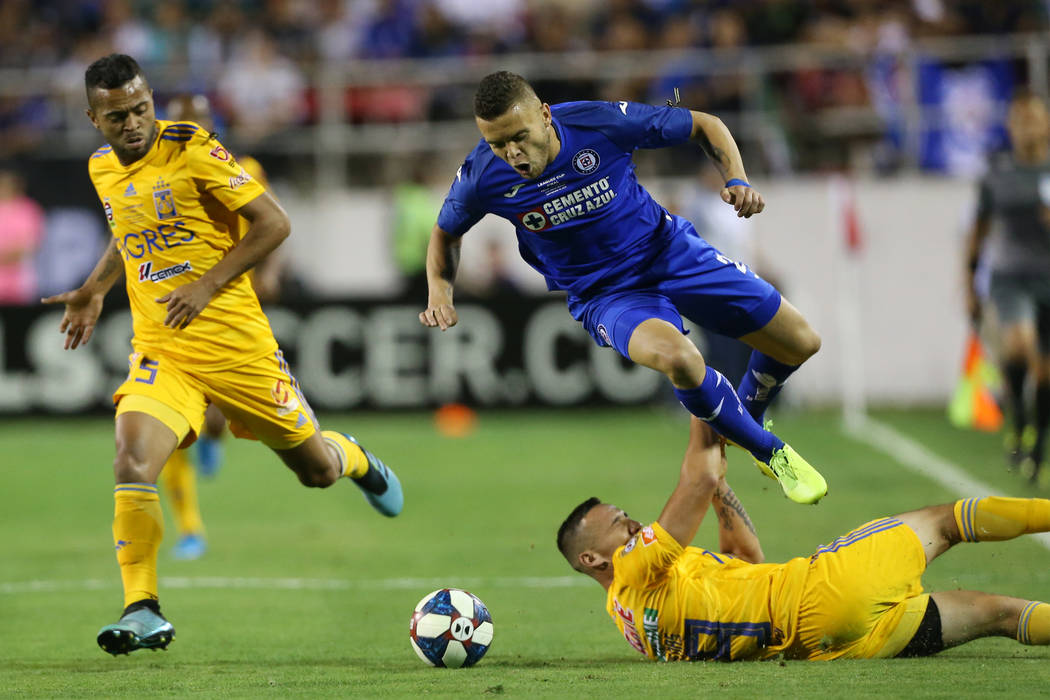 Tigres' Rafael Carioca (5), left, watches his teammate Jesus Duenas (29) slide against Cruz Azu ...