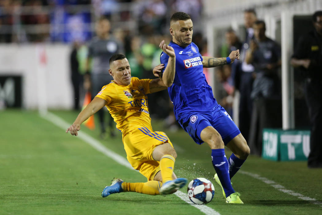 Tigres' Jesus Duenas (29), left, fight for the ball against Cruz Azul's Jonathan Rodriguez (21) ...