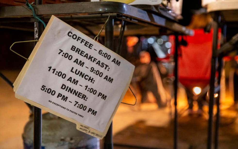 Meal times are posted while friends hang out and warm up by a gas fire pit near the main stage ...