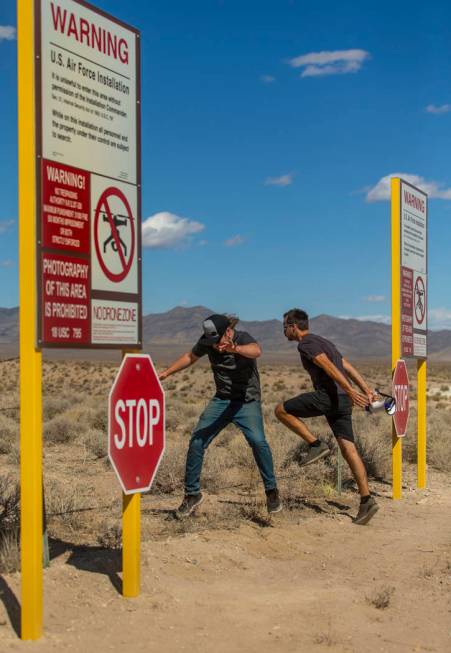 Devin Caldarone, left, and Mike Dye of Los Angeles pretend to cross into Area 51 past the fake ...