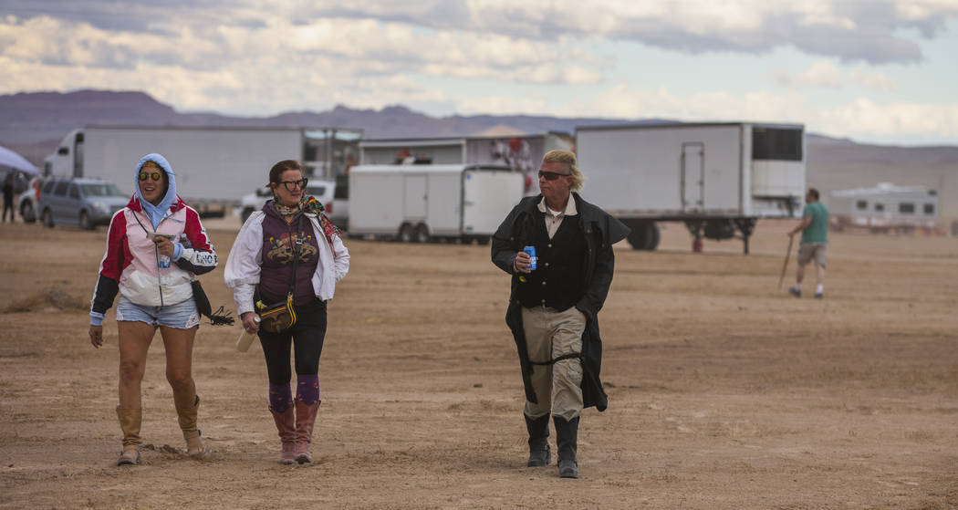 Festivalgoers make their way across the grounds as the winds pick up before the start of Aliens ...