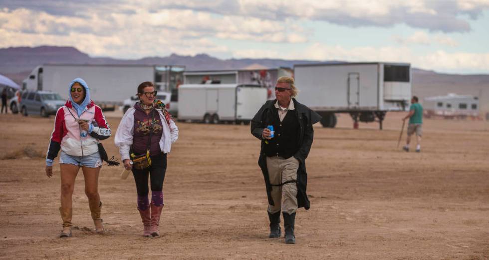 Festivalgoers make their way across the grounds as the winds pick up before the start of Aliens ...