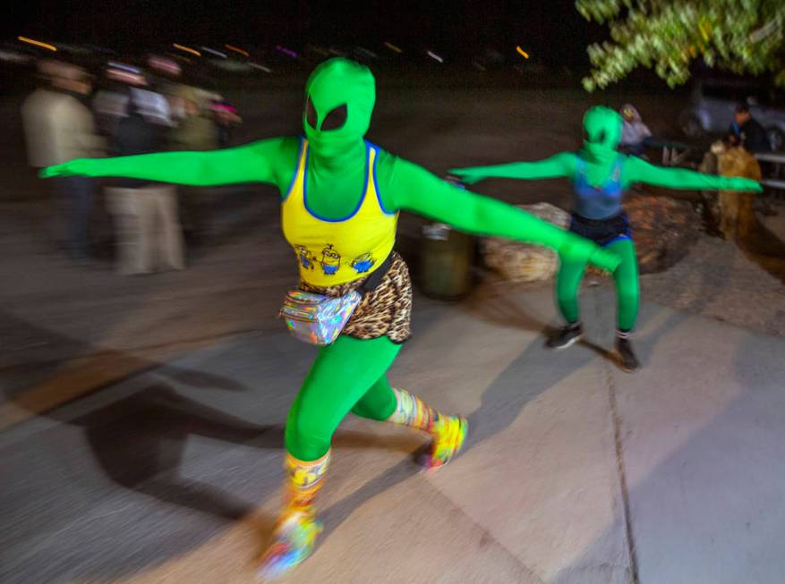 A pair of aliens move about festivalgoers at the Little A'Le'Inn late on the first night of Ali ...