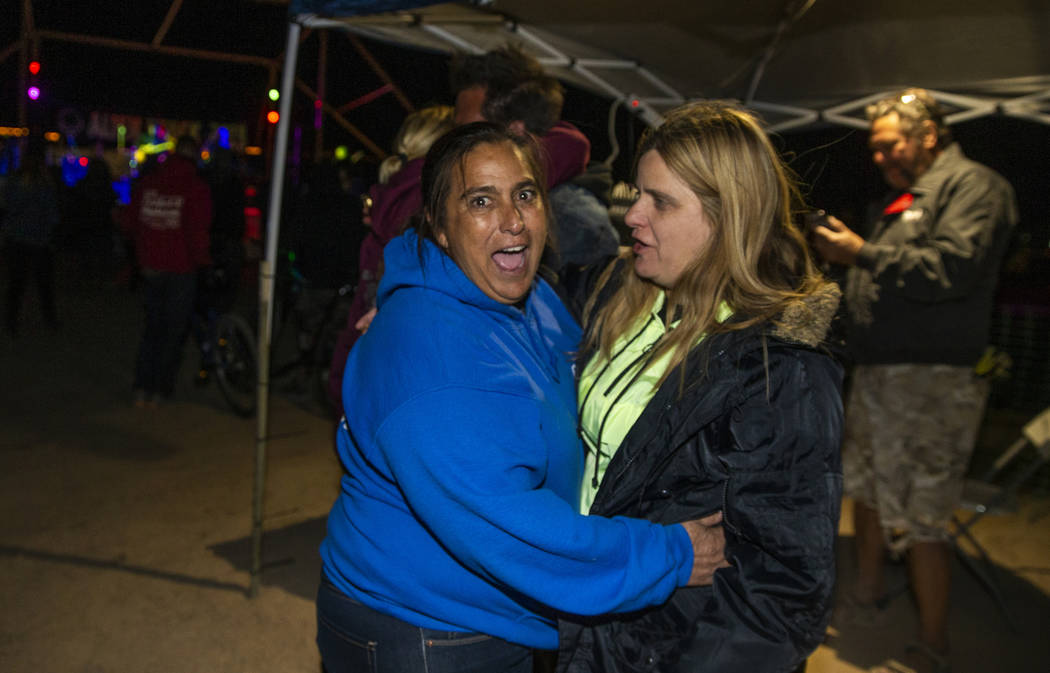 Connie West of the Little A'Le'Inn, left, hugs a festivalgoer as Will Shamberger and Wily ...