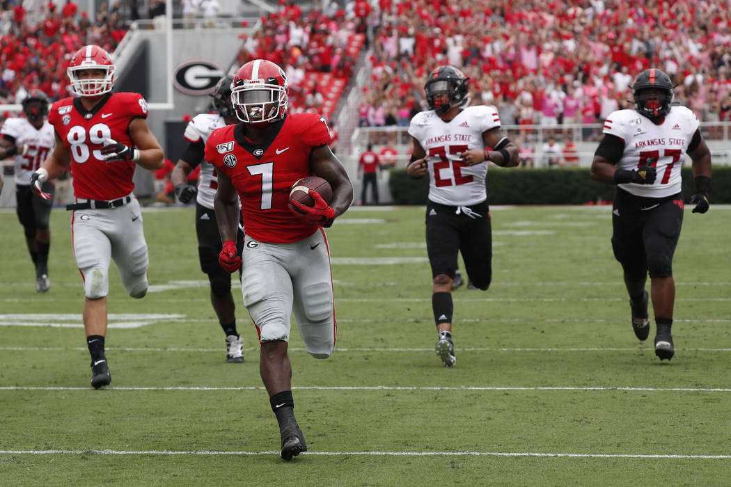 Georgia running back D'Andre Swift (7) is chased by the Arkansas State defense as he scores a t ...