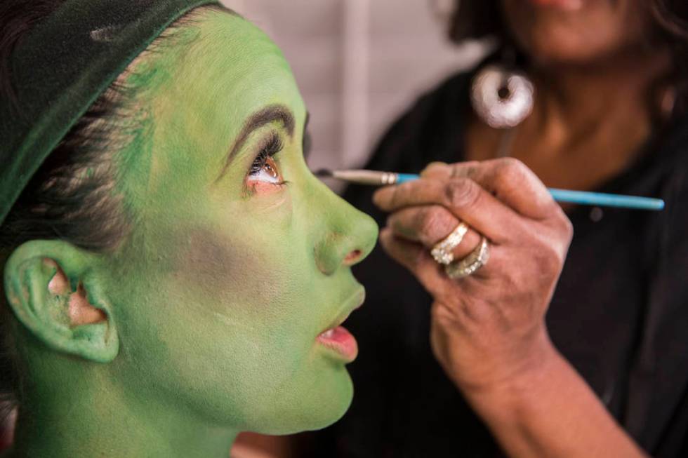 Mariand Torres, left, who plays Elphaba in "Wicked," gets her makeup done by makeup supervisor ...
