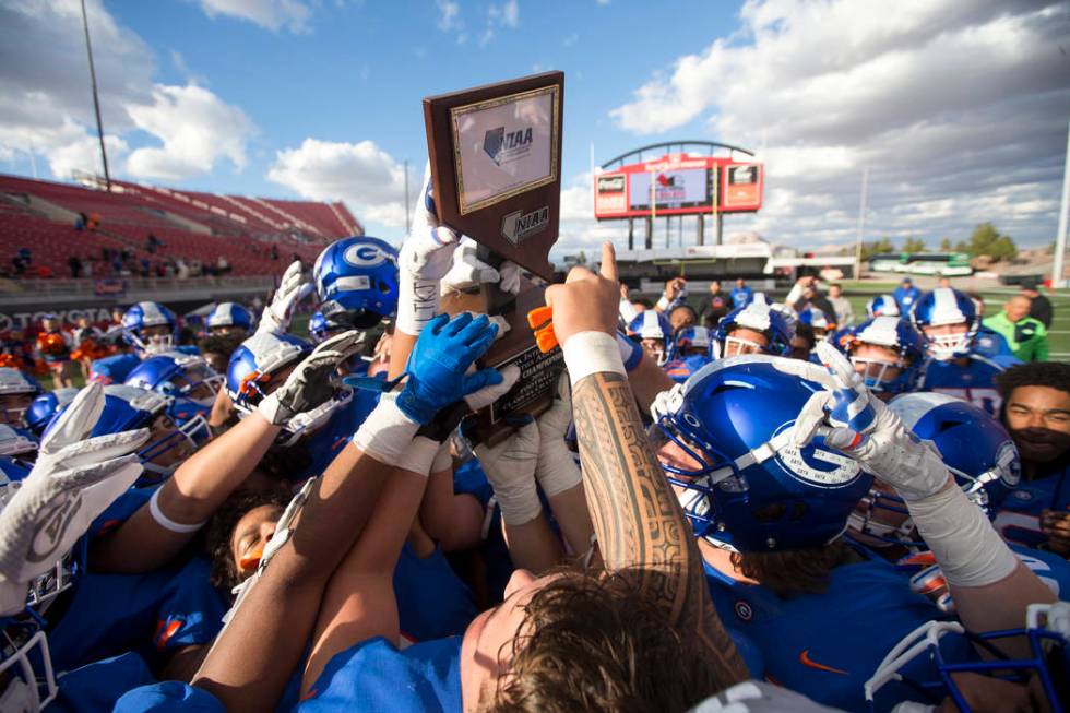 Bishop Gorman players celebrate with the trophy after defeating Reno's Bishop Manogue 69-26 in ...