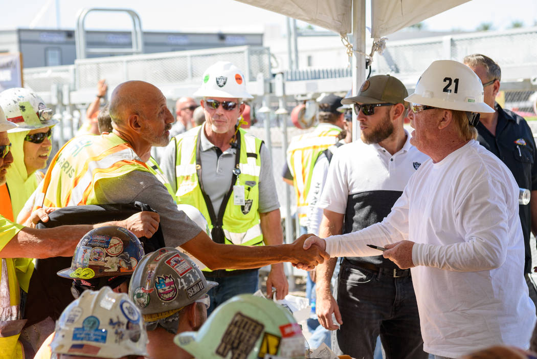Raiders owner Mark Davis shakes hands with a construction worker during a lunch prepared by Lev ...