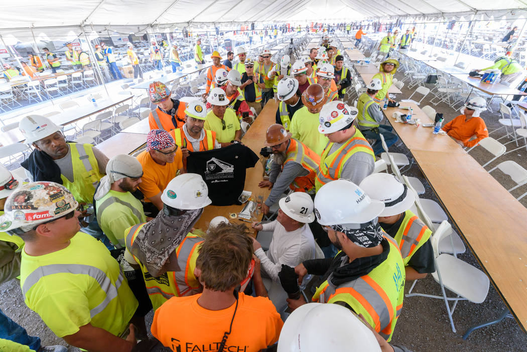Raiders owner Mark Davis signs memorabilia for construction workers during a lunch prepared by ...