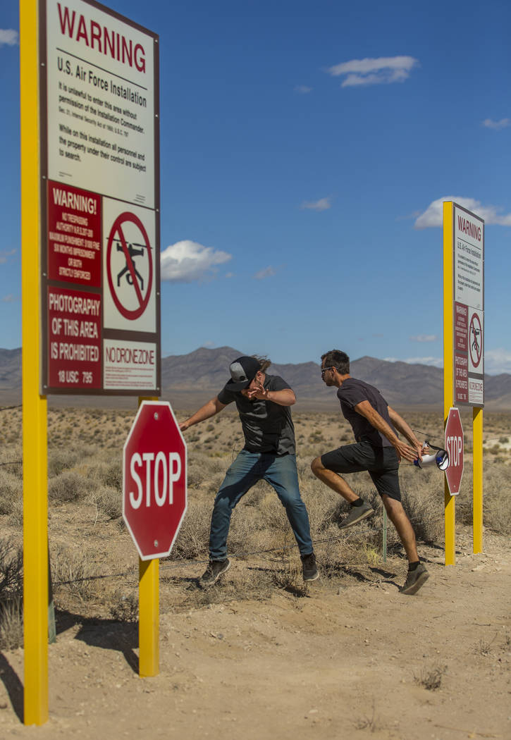 Devin Caldarone, left, and Mike Dye of Los Angeles pretend to cross into Area 51 past the fake ...