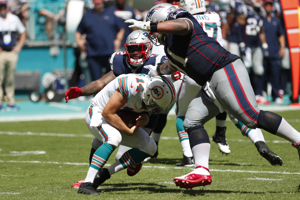 Miami Dolphins quarterback Ryan Fitzpatrick (14) ducks as New England Patriots outside lineback ...