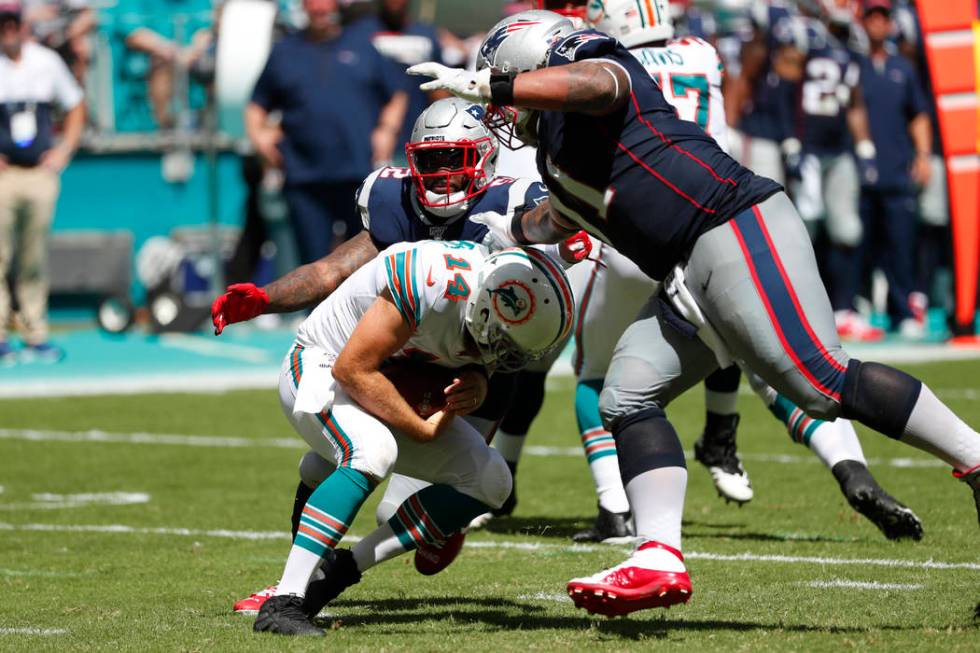 Miami Dolphins quarterback Ryan Fitzpatrick (14) ducks as New England Patriots outside lineback ...