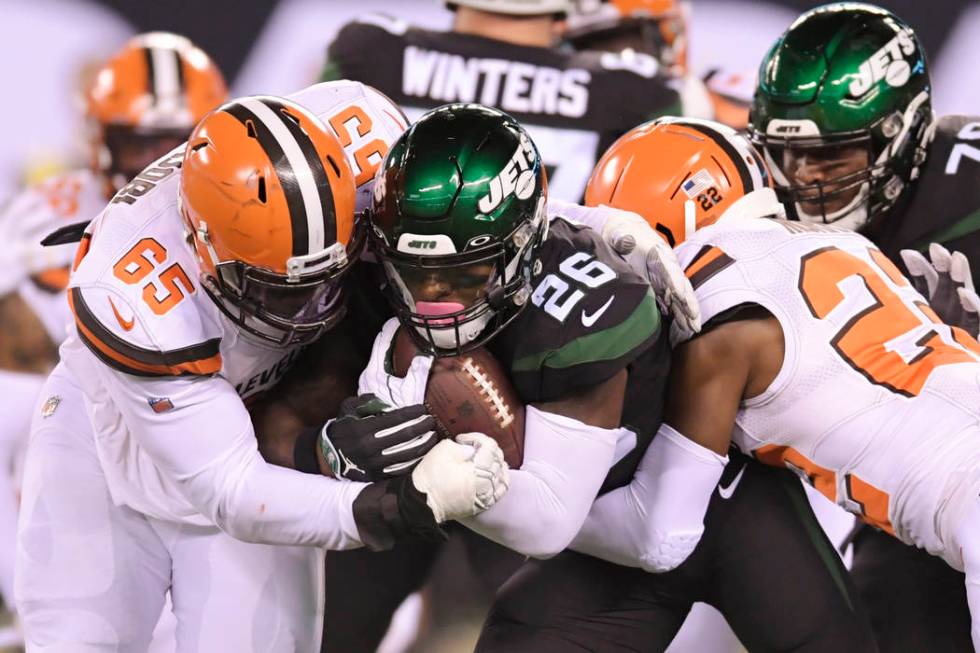 Cleveland Browns' Larry Ogunjobi (65) and Eric Murray (22) tackle New York Jets' Le'Veon Bell ( ...