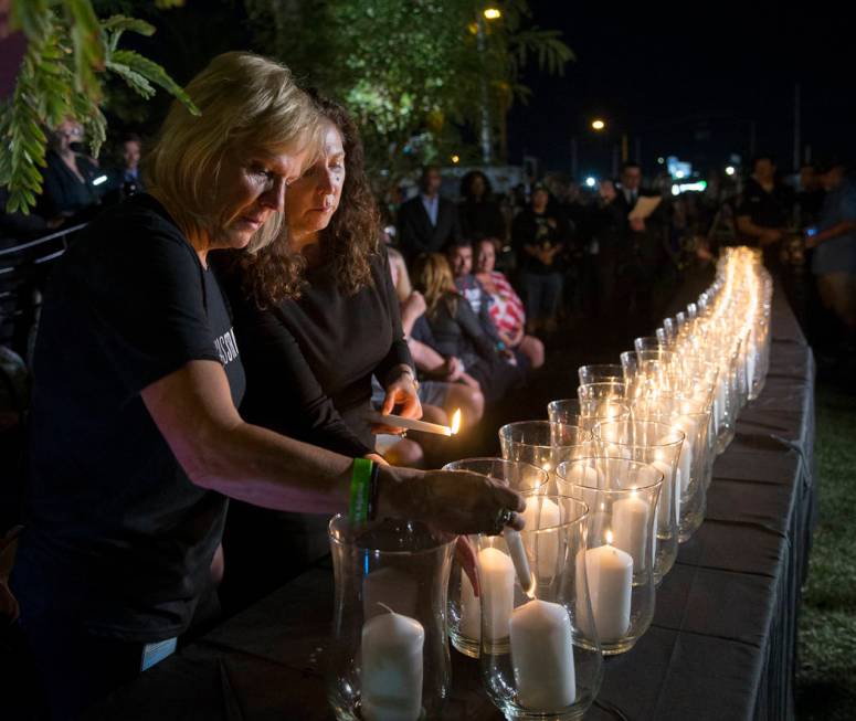 Esther Reincker, left, and Mauricia Baca light candles for the 58 victims of the Oct. 1, 2017, ...